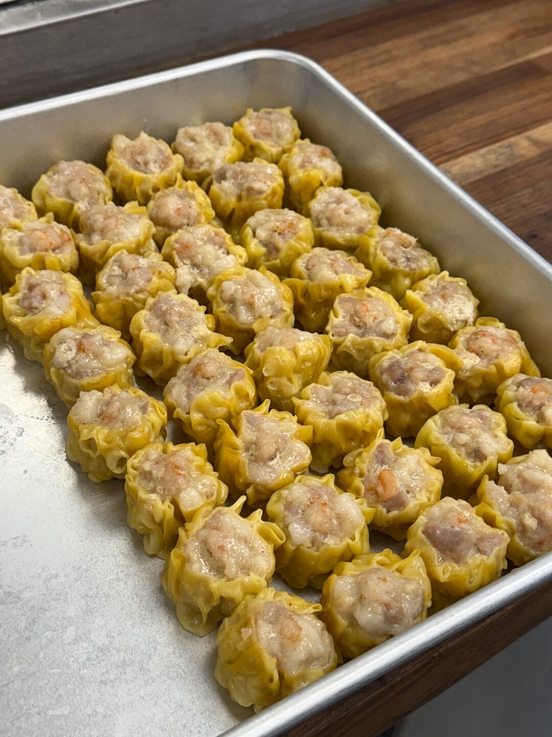 Pork siomai dumplings arranged in a metal tray